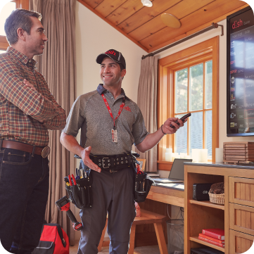Dish worker helping man setup new television.