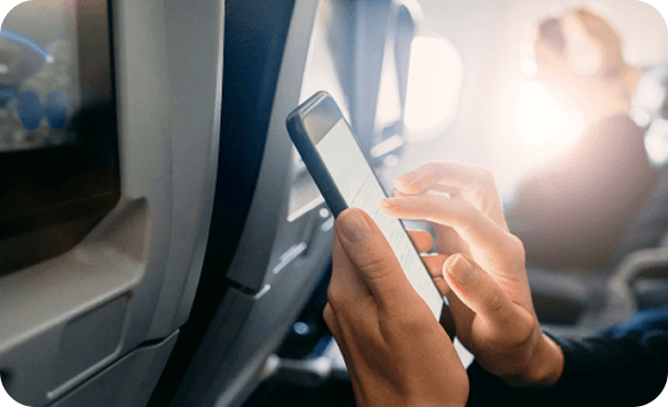 Person using cell phone on plane