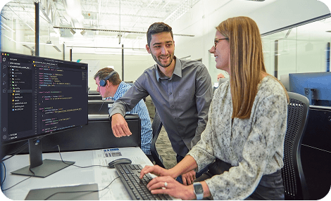 Team members collaborating in an office in front of computers