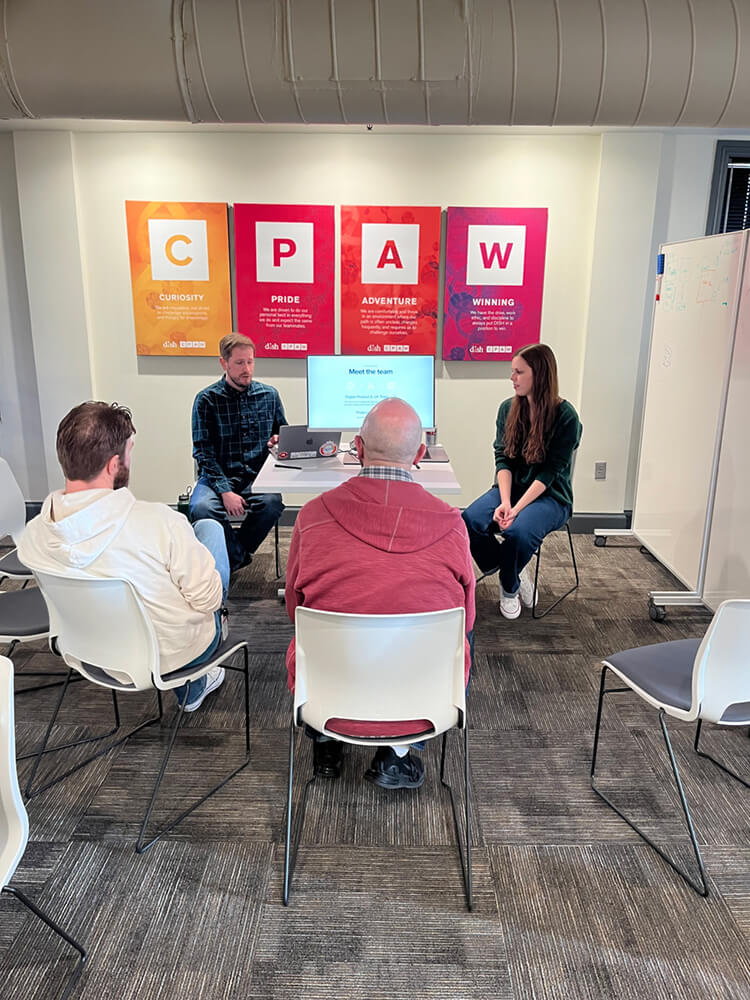 Group of four individuals seated around a screen
