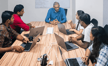 Workers collaborating with their laptops out