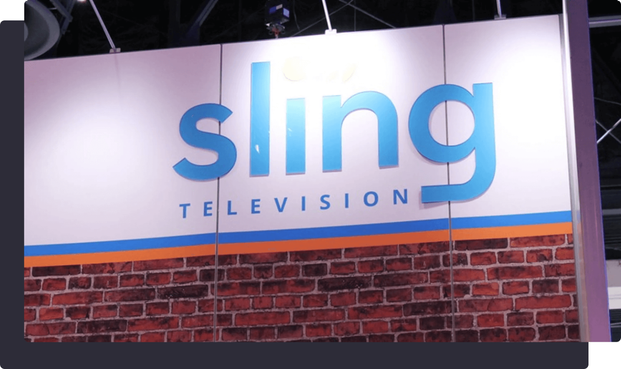 Sling Television logo on a white and brick-textured exhibition booth.
